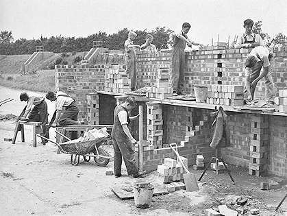 Young gentlemen learn the art of brickwork outside