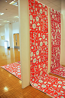 Two long pieces of red and white paper draped over a white board