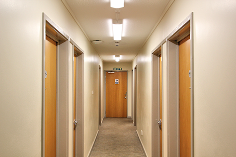 Corridor with doors on either side and one ahead