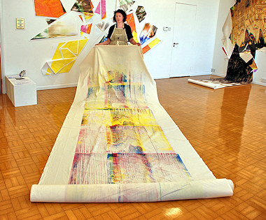 A lady with a long piece of fabric with art screen-printed on it