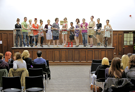 Students on an enclosed stage in a larger hall